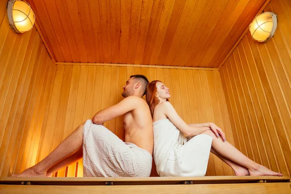 Pelirroja pelirroja mujer y su novio humeante en la casa de baños con el grupo ruso broom.couple en el amor disfrutando de la sauna juntos en el spa — Foto de Stock