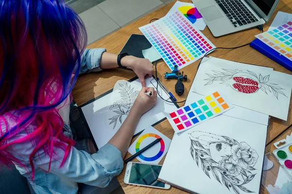 beautiful illustrator woman with pink and blue multi-colored hair draw image on touchscreen in her office studio