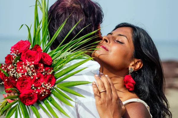 Indiana masculino fazendo proposta com anel de noivado e rosas para sua namorada na praia do mar.Dia dos Namorados em Goa — Fotografia de Stock