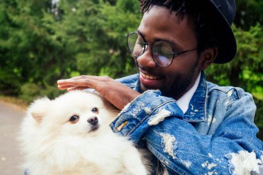 Afro adam parkta tükürük tükürüğüne sarılıyor.