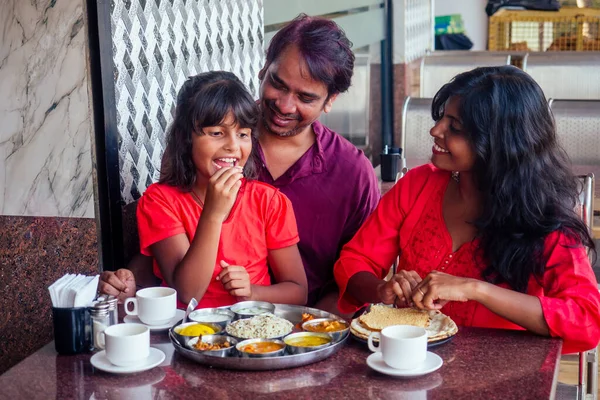 Красивая мать и счастливый отец едят тали с дочерью в кафе и пить чай масала — стоковое фото