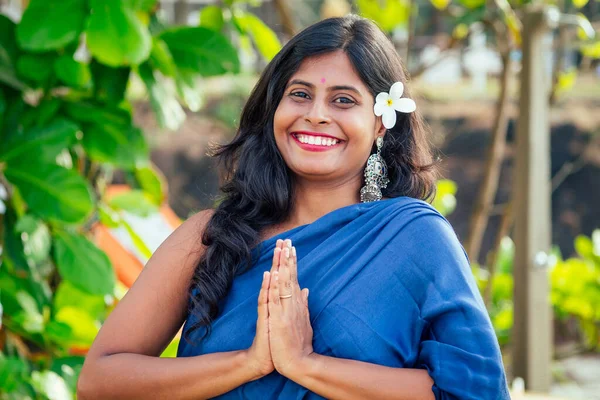 Alegre joven india mujer con flover blanco en el pelo relajante gesto de la mano namaste en la playa en Goa —  Fotos de Stock