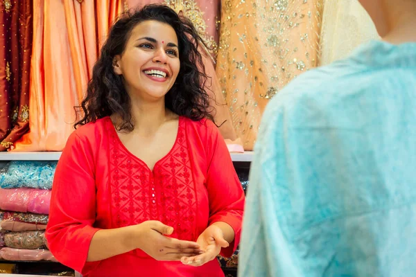 Venditore indiano donne in kurta rosso stand nel suo studio showroom — Foto Stock
