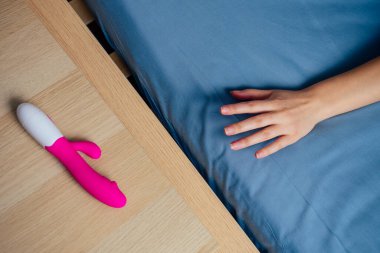 woman and man reaches for the bedside table for sex toy clipart