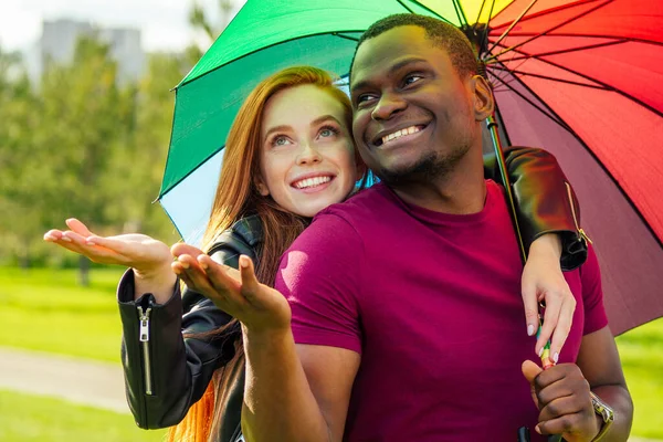 赤髪の生姜女とアフリカ系アメリカ人の男が夏の公園の傘の下で — ストック写真