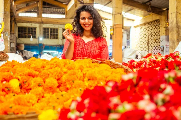 Ritratto di bruna indiana fiorista femminile in bazar floreale guardando la fotocamera e sorridendo — Foto Stock