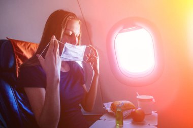 Genç gezgin kadın yemek yemeden önce lombozun yanında otururken antibakteriyel jel uyguluyor. Coronavirüs kavramı.