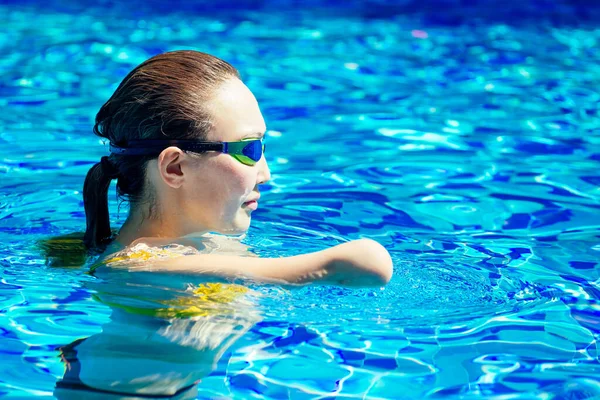Красивая молодая безрукая женщина тренируется плавать в бассейне на тропическом курорте — стоковое фото
