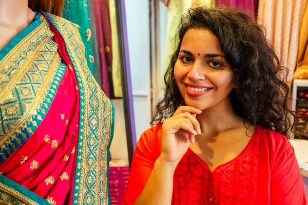 Morena mujer india la elección de un nuevo saree tradición en market.needlewoman diseñador vestido de tela cortina en un maniquí —  Fotos de Stock