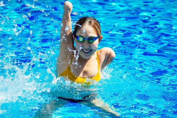 Bella giovane donna senza braccia formazione per nuotare in piscina al resort tropicale — Foto Stock