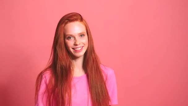 Roux roux femme en rose fond studio sourire et se sentir bien — Video