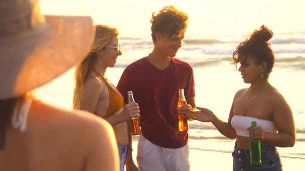 Quatre amis internationaux se rencontrent à la plage pour discuter et passer du bon temps au coucher du soleil — Video