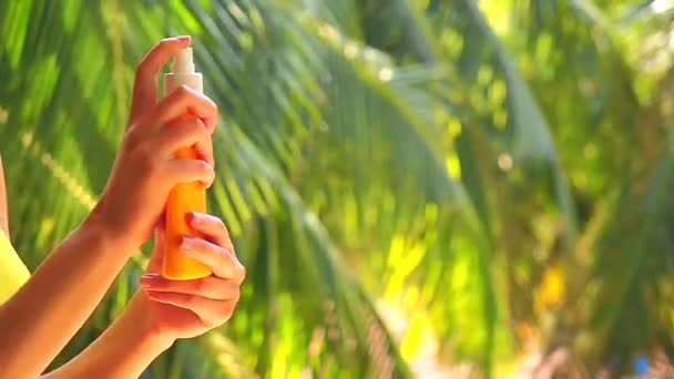 Девушка распыляет спрей для защиты от комаров в тропическом отпуске — стоковое видео