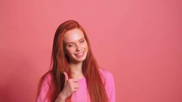 Pembe stüdyo arka planındaki kızıl saçlı kadın gülümse ve kendini iyi hisset. — Stok video
