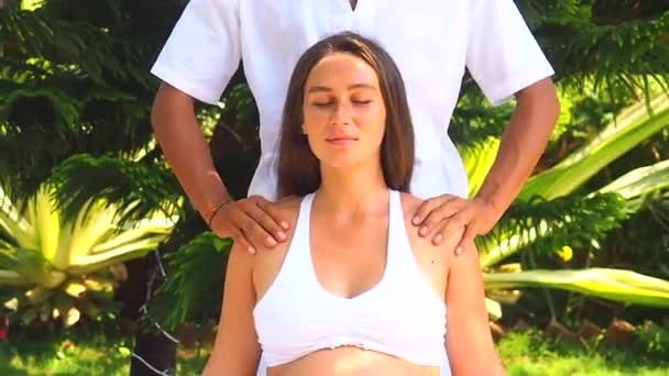 Открытый тропический пляж спа-центр. Беременная женщина получает расслабляющий массаж в тропическом саду — стоковое видео