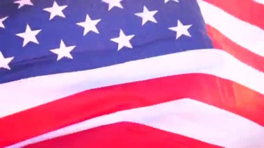 Güneşin doğuşunda Amerikan bayrağıyla denizde güzel genç bir kadın.