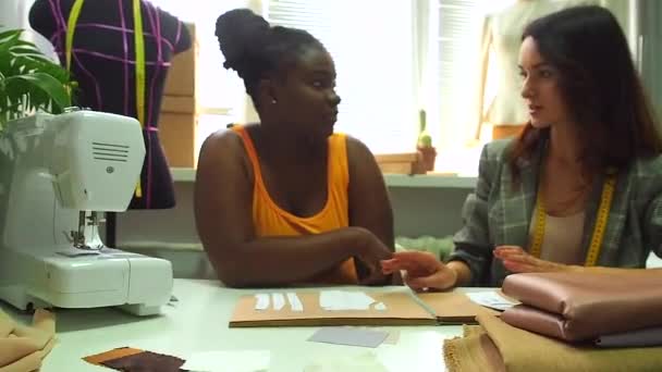 Afrikaans amerikaanse vrouw praten met kleermaker over nieuwe kleding collectie .sewing cursussen student met master — Stockvideo