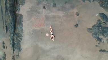 Yukarıdaki plajda genç bir kadının hava aracı görüntüsü.