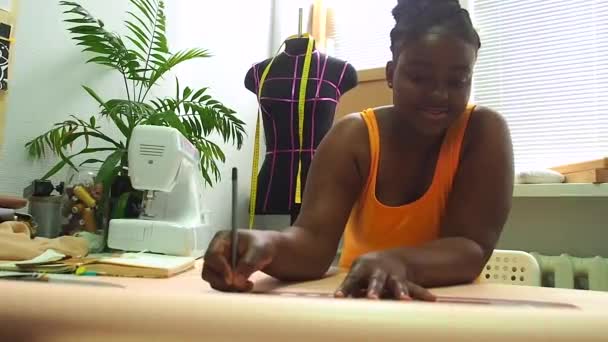 African american woman drawing the pattern with tailors ruler in workshop place — Stock Video