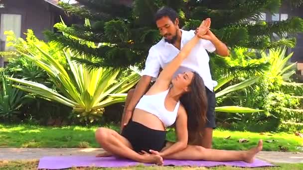 Happy pregnancy wife and asian husband doing couple meditation in green park by sea beach — Stock Video