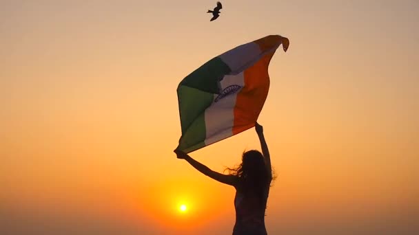 Vatanseverlik, bağımsızlık günü 15 Ağustos ve bayram kavramı. Dağların tepesinde ulusal Hint bayrağı taşıyan genç bir kadının arka tarafı. — Stok video