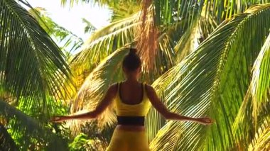 Yoga yapan genç bir kadın dışarıda, doğal ortamda nefes alıyor.