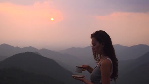 Güzel kız Hindistan tepelerindeki organik taze kahvenin ya da masala çayının tadını çıkar. Akşam günbatımında manzarası çok güzel. — Stok video