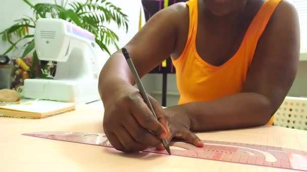 Afrikanerin zeichnet Muster mit Schneiderlineal in Werkstatt — Stockvideo