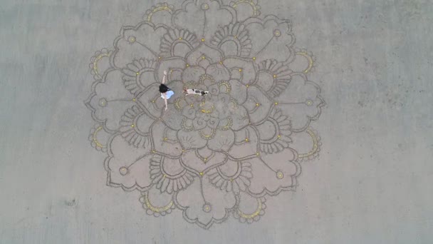 Frau zeichnet das große Mandala am Sand und tanzt im leeren Strandblick oben vom Drohnen-Quadrocopter. Konzept der Weiblichkeit und Unabhängigkeit — Stockvideo