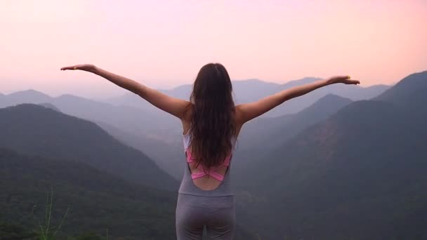 Beautiful girl making body stretching in india hills with top nice view at evening sunset — Stock Video