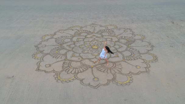 Mujer dibujando el mandala grande en la arena y bailando en la playa vacía vista superior desde el dron quadrocopter.concept de la feminidad y la independencia — Vídeo de stock