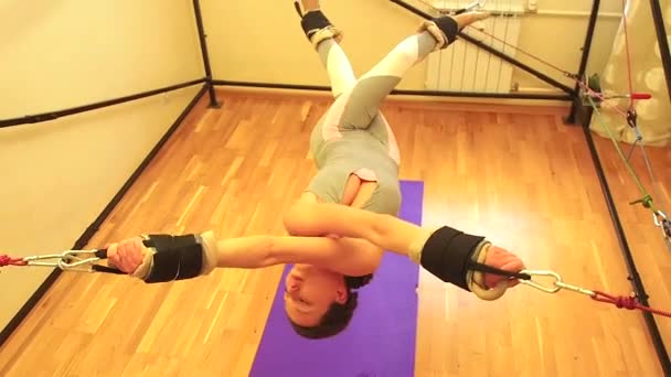 Deportiva joven mujer caucásica haciendo ejercicios de estiramiento de los músculos de cuerpo completo entrenamiento en la correa aerobia estiramiento en el gimnasio, alfombra de yogui — Vídeo de stock