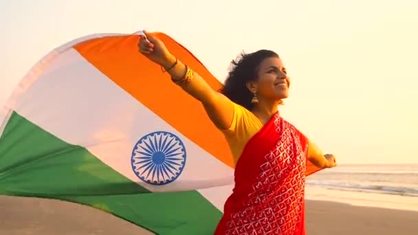 Patriotismo, día de la independencia 15 de agosto y vacaciones concept.happy sonriente joven con bandera nacional india en la playa de verano — Vídeos de Stock