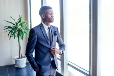 Modern bir ofiste panoramik penceresi olan yakışıklı Afro-Amerikalı.