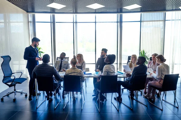 A group of successful afro americans, europeans ,arabic and korean businessman and businesswoman working in the office with large glass windows — Stock Photo, Image
