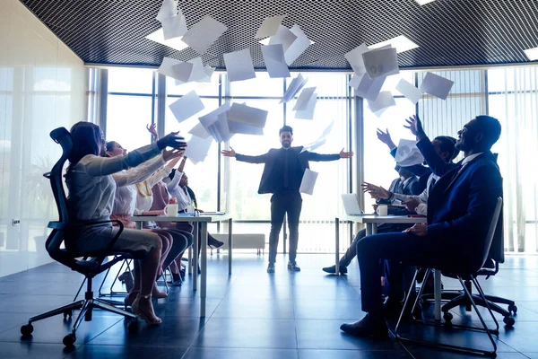 Group of business people rejoicing in closing the quarter successfully tossing up paper documents in the modern office panoramic window — Stock Photo, Image