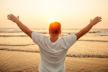 Genç adam sahilde tek başına Goa 'da gün batımını seyrediyor.