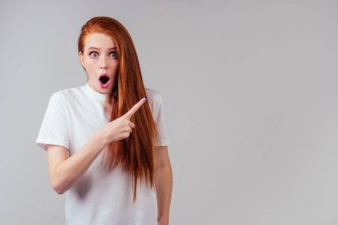 Kızıl saçlı, kızıl saçlı kadın boşluğu işaret ediyor.