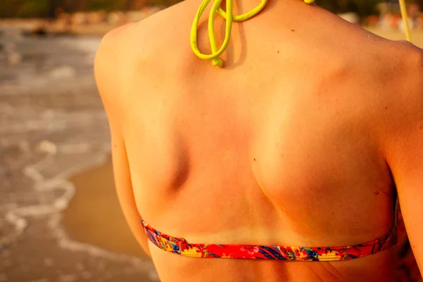 Chica aplicando loción solar en la playa vista trasera — Foto de Stock