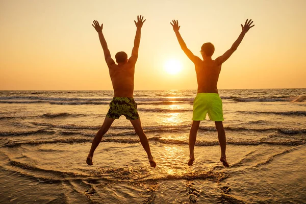 Urlauberpaar spaziert verliebt am Strand bei Sonnenuntergang goa — Stockfoto