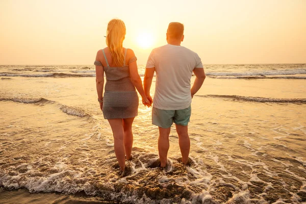 Пара відпусток, що гуляє на пляжі разом закохані в заході сонця Гоа — стокове фото