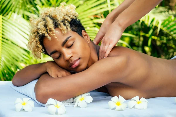 Mulher brasileira recebendo de volta e ombros massageando no spa ao ar livre Ayurveda centro na Índia verde fundo tropical — Fotografia de Stock