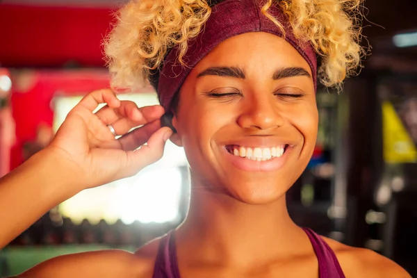 Afro-américaine femme écouter de la musique de motivation avec des écouteurs et sourire — Photo