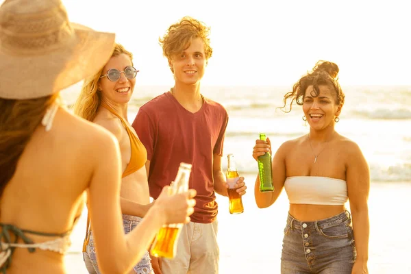 Fröhliche internationale Freunde trinken Smoothie-Saft aus Glasflasche am Strand — Stockfoto