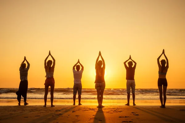 Шесть здоровых людей в положении хата с поднятыми руками и дышащими полной грудью на пляже Гоа Индия на закате — стоковое фото