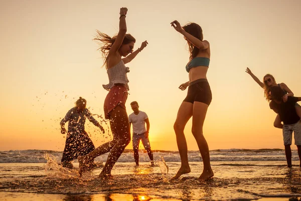 Pessoas felizes multinacionais multiculturais correndo para o sol despreocupado e felicidade, férias no mar — Fotografia de Stock