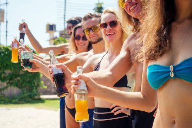 En iyi arkadaşlar yüzme havuzunda ferahlarken limonata içerler.