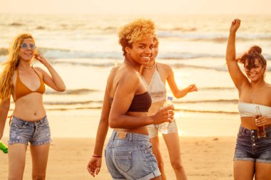 Afrika kökenli Amerikalı bir kadın elinde plastik bir şişe su tutuyordu. Karışık ırklardan oluşan bir grubun arkasında dans ediyor ve gün batımında limonatayla eğleniyordu.