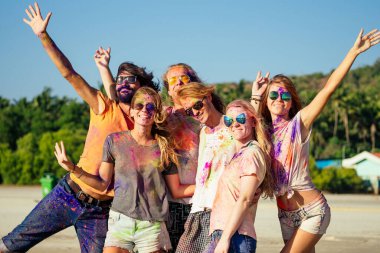 Mutlu insanlar renkli holi boyalarıyla Goa sahilindeki şenlikte oynuyorlar Hindistan 'da.