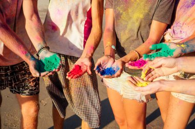 Çok uluslu çok kültürlü karışık ırk dostları Goa 'daki kumsalda Holi tozunda